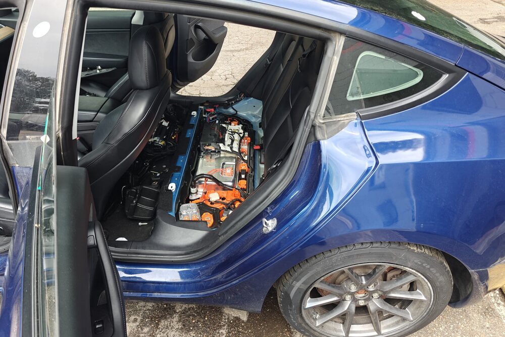 Blue Tesla with the rear seat removed to access the high-voltage system during service at Iron Wolf Motors in Worcester, MA