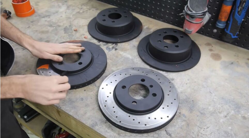 Brake rotors prepared on the workbench for a brake job at Iron Wolf Motors in Worcester, MA