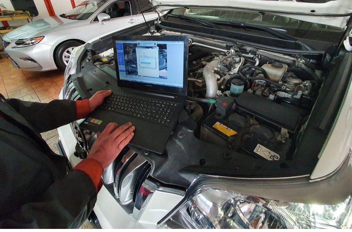 Diagnostic laptop connected to the engine bay during an electrical fault trace at Iron Wolf Motors in Worcester, MA
