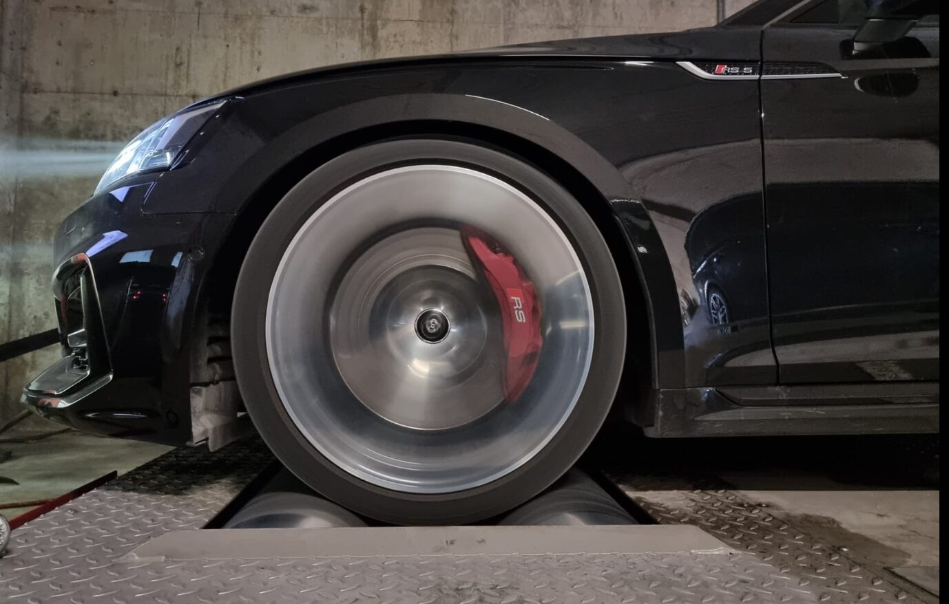 Black Audi RS 5 on the dyno rollers with red RS-branded brake calipers during service at Iron Wolf Motors in Worcester, MA
