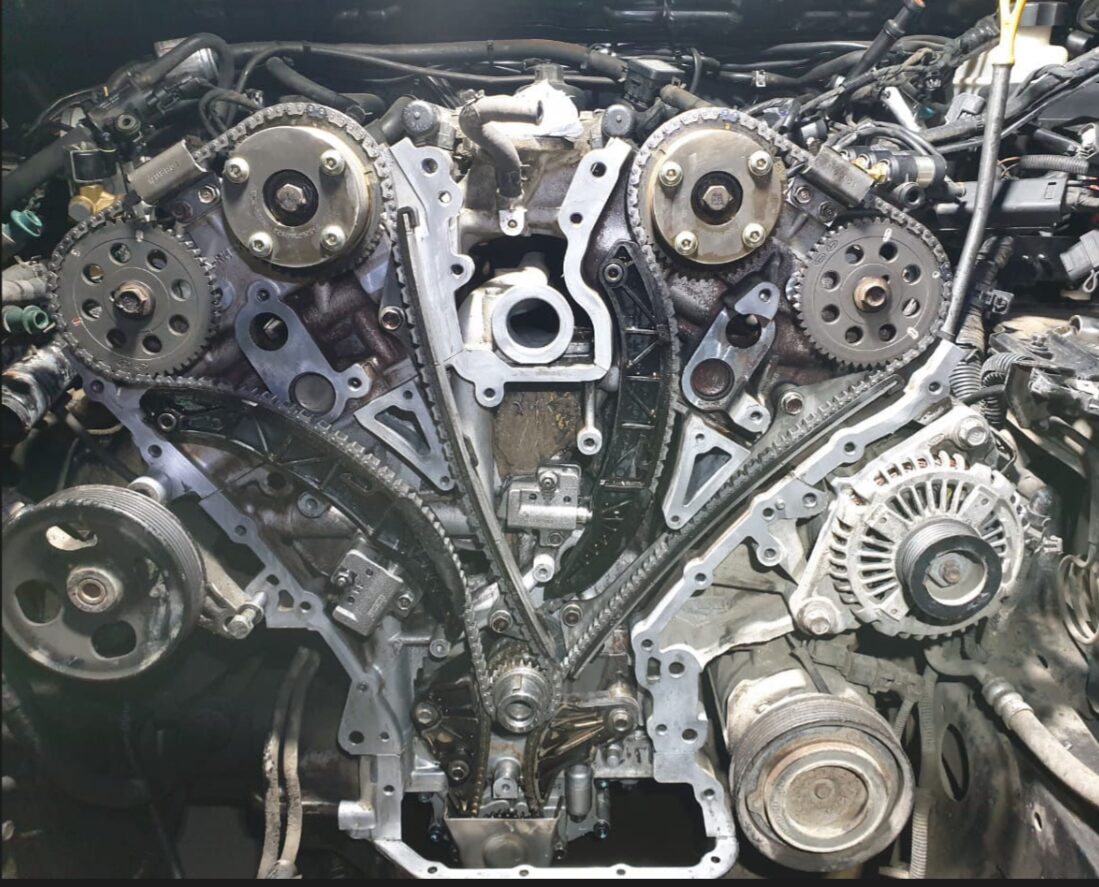 Engine timing chains and sprockets exposed during a complex repair at Iron Wolf Motors in Worcester, MA
