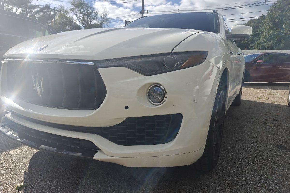 White Maserati Levante in the lot at Iron Wolf Motors in Worcester, MA, photographed from the front corner