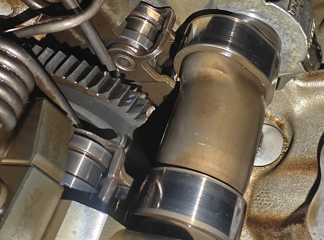 Close-up of the BMW 535i valvetrain with the valve cover off: a geared shaft segment, intermediate levers, valve springs and a camshaft lobe
