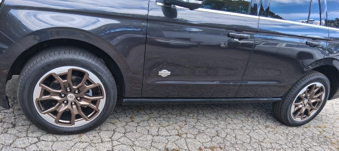Side of a dark Ford Expedition King Ranch with refinished bronze two-tone wheels front and rear