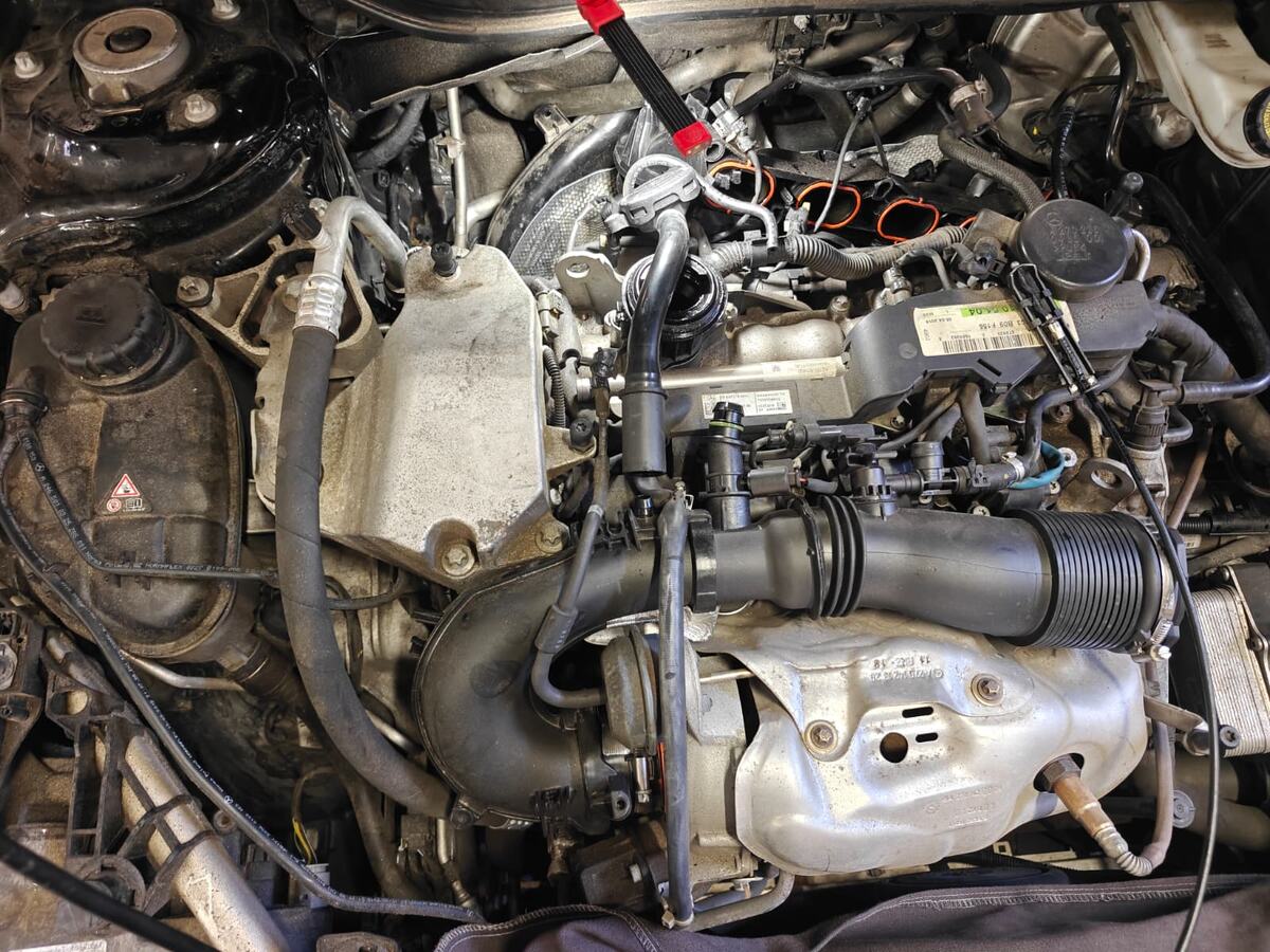 Mercedes-Benz GLA250 engine bay with the engine cover, intake ducting and surrounding components removed to gain access to the oil filter housing and oil cooler on the front of the block