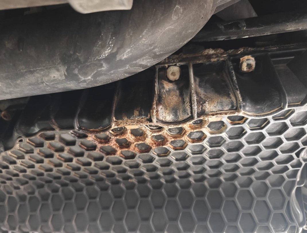 Crusted, rust-colored deposits along the bottom of the radiator of a 2017 Volkswagen Jetta, seen from underneath