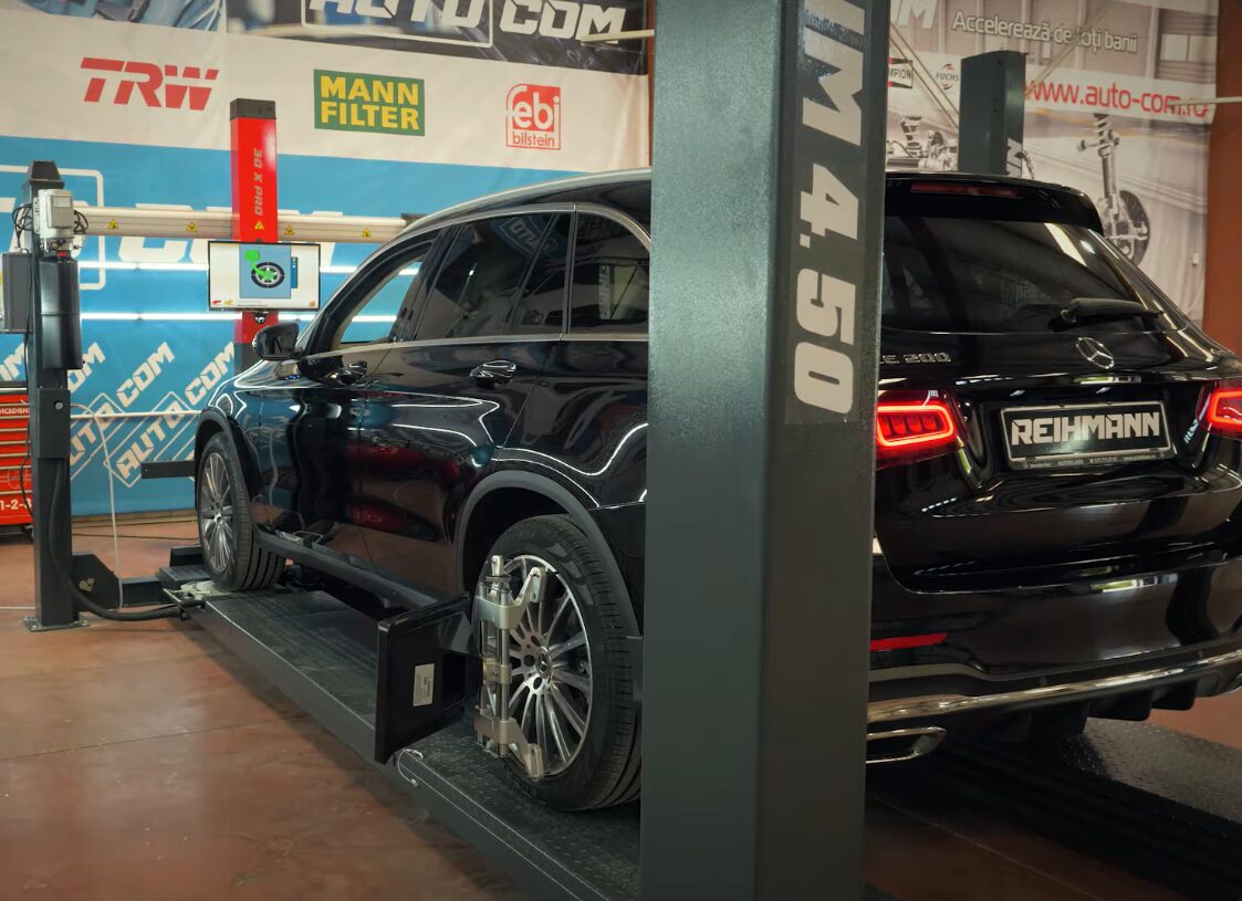 Vehicle on the alignment rack with sensor heads attached at Iron Wolf Motors in Worcester, MA