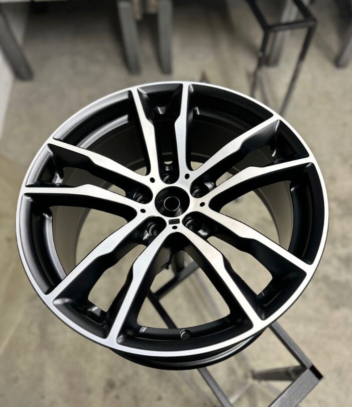 Refurbished black multi-spoke alloy wheel after reconditioning at Iron Wolf Motors in Worcester, MA